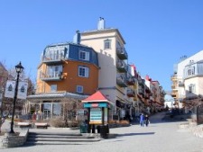 end view of an urban street with different building heights, masses, and materials