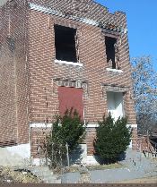 unattended houses impact entire neighborhood brick home with ground level windows boarded and upper level windows open to the elements