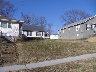 three homes with middle one set back much further from street than the others