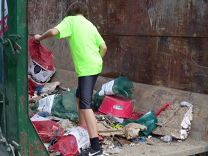 volunteer inside a dumpster organizing it