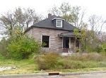 house and shrubbery in poor condition