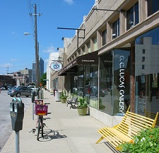 single-story commercial spaces may spur revitalization but lack opportunity for second-story residential uses single-story commercial strip with art gallery and yellow bench visible
