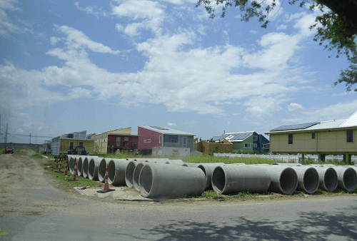 large culverts in foreground houses in background after hurricane large culverts in foreground houses in background after hurricane