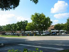 very wide street with nondescript strip retail center and parking in front
