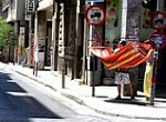 colorful hammock on sidewalk in front of a store