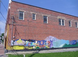 painting looks out of scale because it reaches only a few feet above the ground