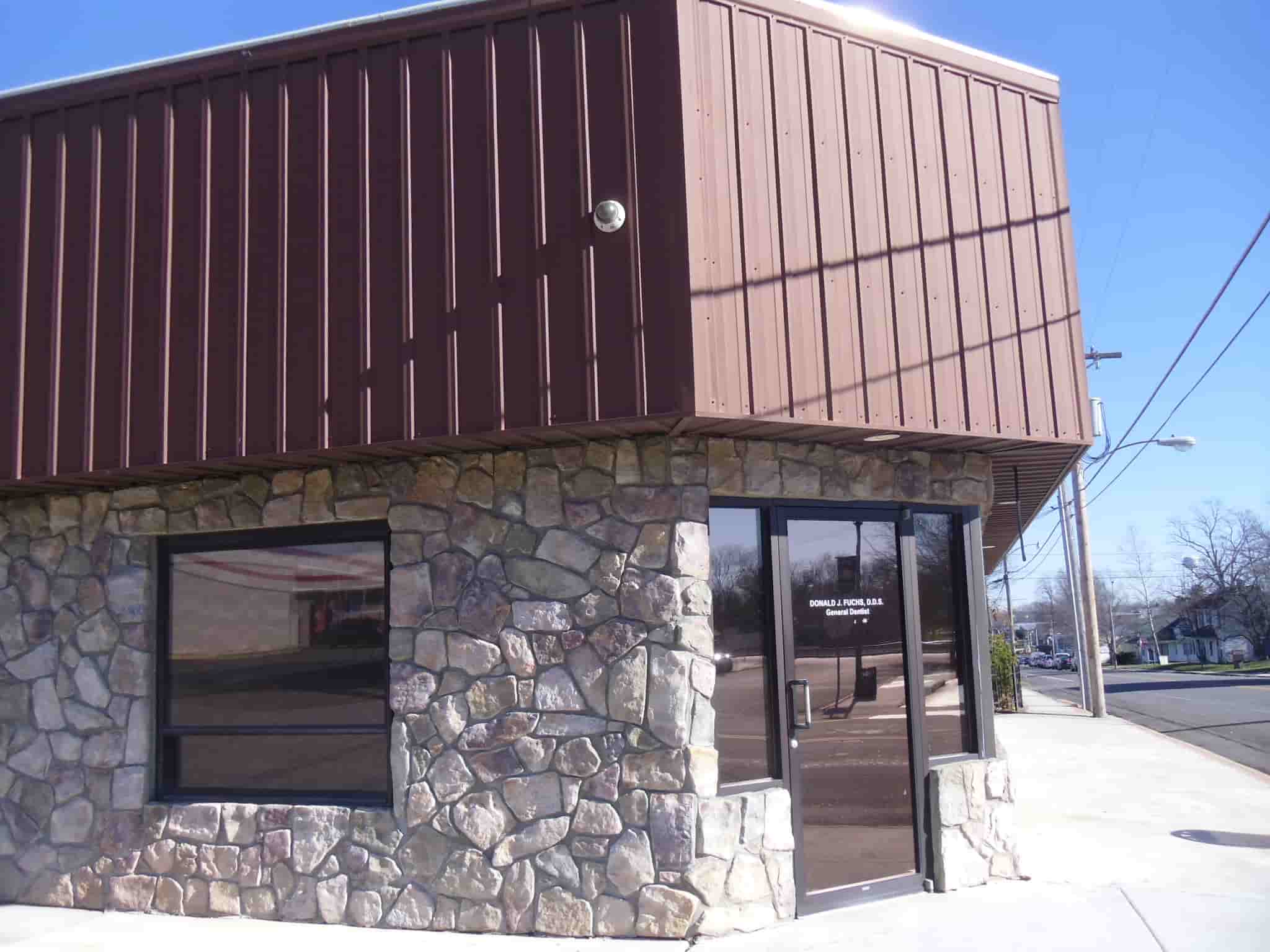 stone building with metal siding as the second story