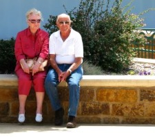 older couple resting on seating wall