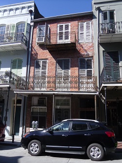 neighborhood planning can address congestion, intensity of uses, parking, and housing affordability issues raised by this photo multi-story, mixed-use buildings and parked cars lining a somewhat narrow street in a New Orleans neighborhood