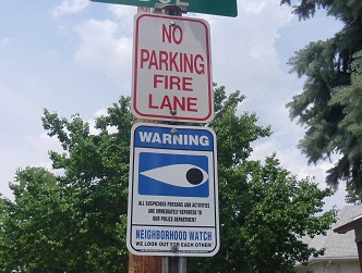 Watch Sign Aimed at Deterring Burglaries neighborhood watch sign posted in residential area under street sign