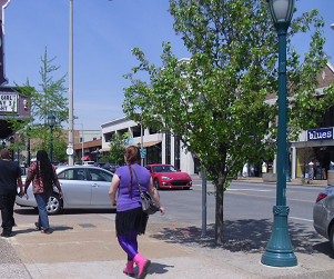 pedestrian comfort involves shade and good lighting as well as a sidewalk pedestrians on very wide sidewalk in business district