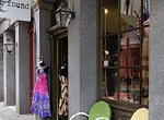 colorful shop with merchandise and chairs on sidewalk