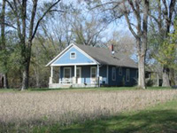 pastel blue frame home in rural setting