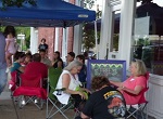 tent and activities on the sidewalk during a street fair