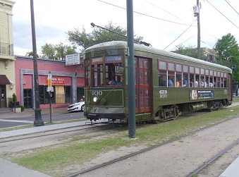 Proximity to Fixed Transit Such as Light Rail, Street Cars, or Trams Necessary for Good TOD Saint Charles streetcar in New Orleans near stop with commercial activity